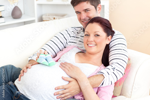 Foto: Portrait of a caucasian pregnant woman holding baby shoes and of Portrait of a caucasian pregnant woman holding baby shoes and of