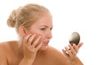 Woman finding an acne on her cheek