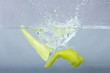 green chilli thrown in water with gray background