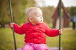 young cute girl swinging on playground in park young cute girl swinging on playground in park