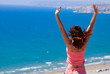 Red-haired girl is standing on rock and looking at sea Red-haired girl is standing on rock and looking at sea