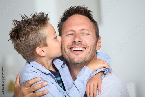 Photo: Little bond boy giving a kiss to his dad Little bond boy giving a kiss to his dad