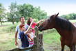 Parents and children petting horses in countryside