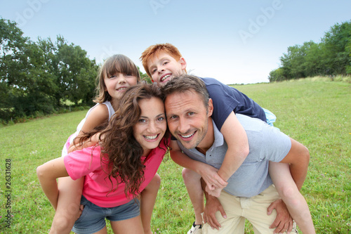 Photo: Parents doing piggyback to their children Parents doing piggyback to their children