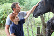 Parents and children petting horses in countryside