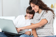 Closeup of mother and child at home with laptop computer