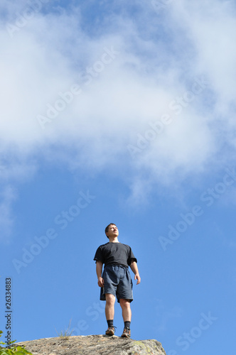 Photo: A young man stands on a cliff top, and seriously, A young man stands on a cliff top, and seriously,