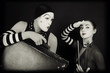 mimes woman and man with suitcase and violin