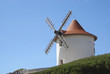 White windmill against blue sky located in Corsica