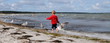Kleines Mädchen am Strand mit Möwen
