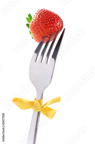 Photo: Fruit diet: strawberry on a fork, isolated on white Fruit diet: strawberry on a fork, isolated on white