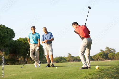 Photo: Group Of Male Golfers Teeing Off On Golf Course Group Of Male Golfers Teeing Off On Golf Course