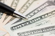 Dollar banknotes and pen