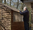 Man fixing garden shed roof