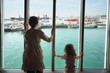 woman and daughter standing and looking at ships in Qaboos Port