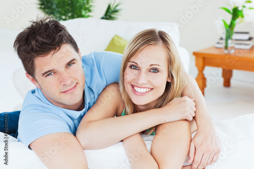 Photo: Smiling beatiful couple sitting on a sofa Smiling beatiful couple sitting on a sofa