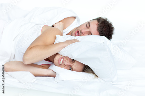 Photo: upset woman in bed with her boyfriend snoring upset woman in bed with her boyfriend snoring