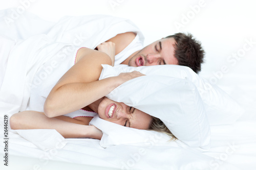 Photo: Couple in bed while the woman is trying to sleep Couple in bed while the woman is trying to sleep