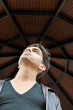 Young man looking up under a kiosk