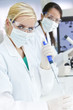 Female Research Scientist With Pipette & Flask In Laboratory