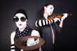 Two mimes playing a violin for the money