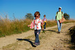 Father with two kids walking by the road