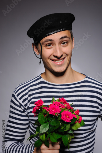 Photo: Funny emotional romantic sailor man holding rose flowers prepare Funny emotional romantic sailor man holding rose flowers prepare