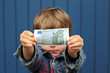 Junge hält 5-Euro-Schein hoch