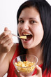 eine junge Frau isst Corn flakes