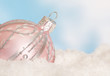 Pink christmas bauble in snow