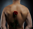man in a yellow shirt holding a red rose