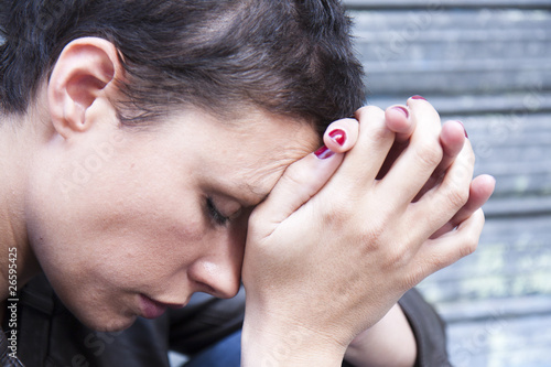 Photo: jeune femme fatiguée, la tête appuyée contre ses mains jeune femme fatiguée, la tête appuyée contre ses mains
