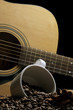 coffee mug beans cinnamon sticks and guitar on black