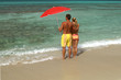 Paar mit Sonnenschirm am Strand