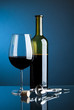 A glass of red wine with bottles on a blue background