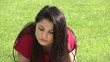 Serious woman reading a bokk lying on the grass
