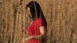 Peaceful woman walking in a wheatfield