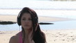 Serious woman listening music with headphones on the beach