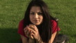 Captivating woman with an apple lying on the grass