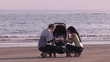 Young couple taking care of their baby on the beach