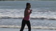 Attractive woman stretching and running on the beach