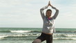 Woman practicing yoga on the beach