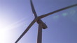 Close up of a wind turbine turning against a sunny sky