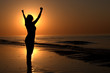 Silhouette of a woman showing achievement on a beach sunset Silhouette of a woman showing achievement on a beach sunset