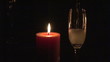 Candle and  flute of champagne in the dark