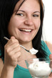 Foto: eine junge Frau isst Joghurt aus einem Glas eine junge Frau isst Joghurt aus einem Glas