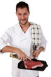 Young attractive caucasian male cook with, preparing steak