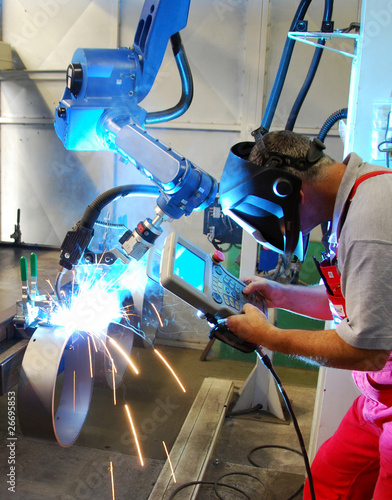 Foto: Schweisser bedient Roboter Schweisser bedient Roboter
