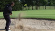 Rear view of a golfer on the sand trying the eighth hole