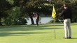 Video: Golfer on the green with assistant missing the hole Golfer on the green with assistant missing the hole